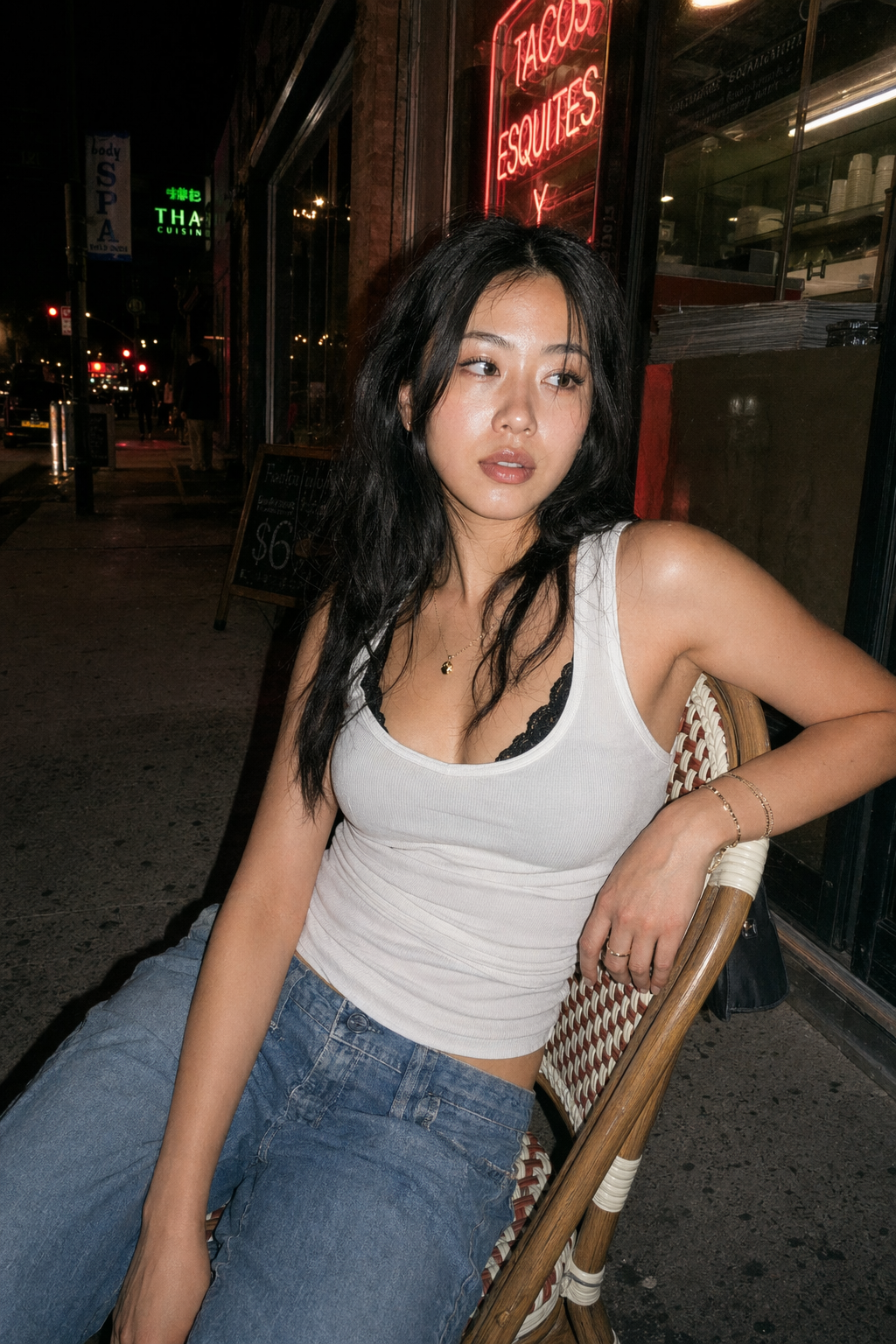 Nighttime flash street portrait, woman on woven café chair, neon city, film grain, GPT Image 2