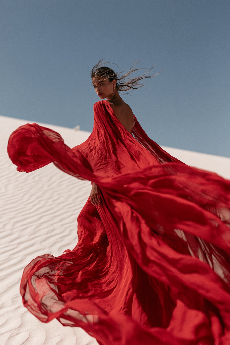 Variation 1 of 4 from one Midjourney V8 run: crimson gown on white dunes